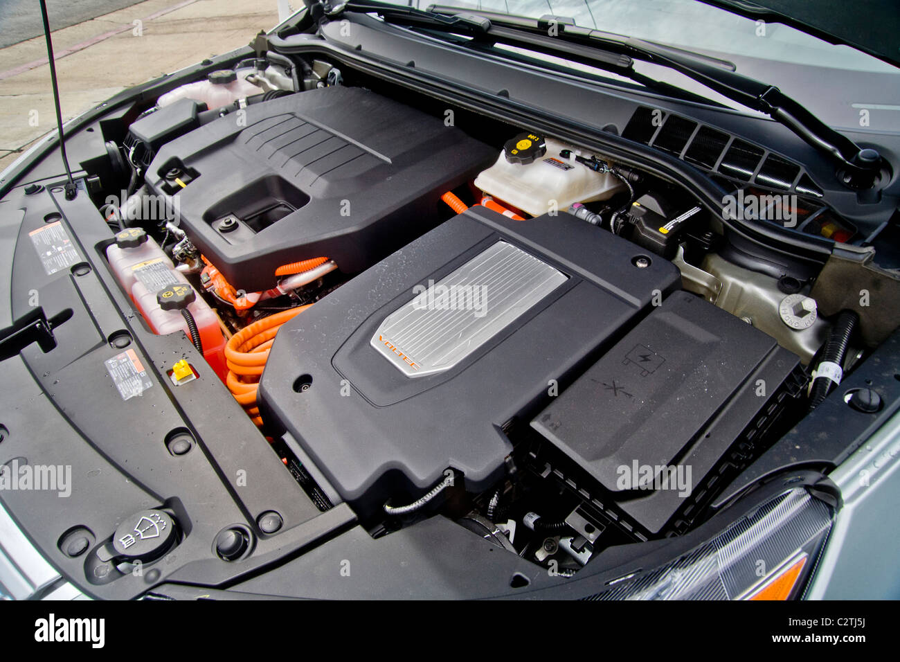 The engine compartment of a Chevrolet Volt hybrid gas/electric car. Right side: the power inverter in top of the electric motor. Stock Photo