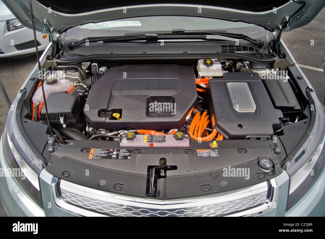 The engine compartment of a Chevrolet Volt hybrid gas/electric car. Right side: the power inverter in top of the electric motor. Stock Photo