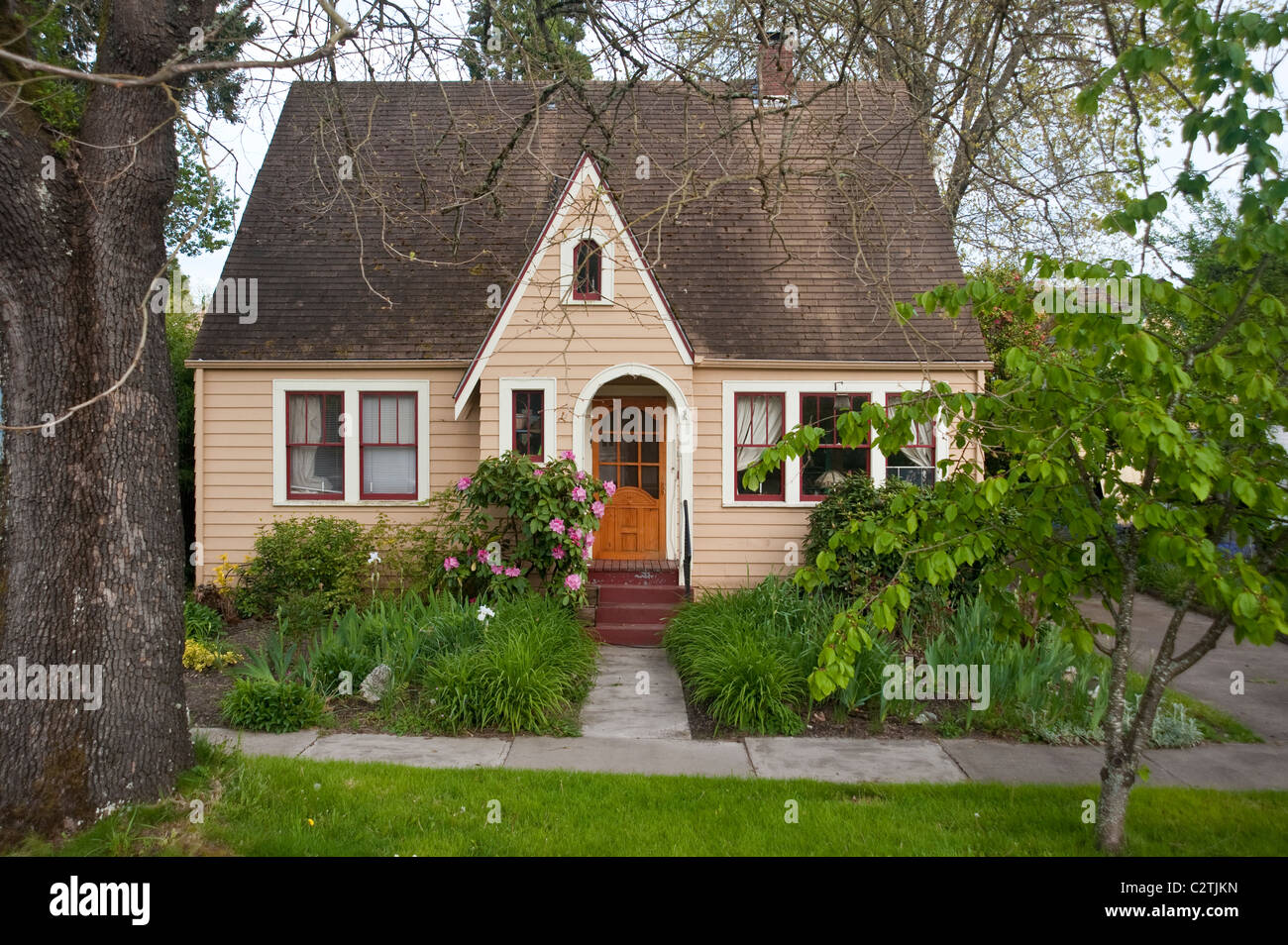 Older clapboard bungalow surrounded by green shrubs Stock Photo Alamy