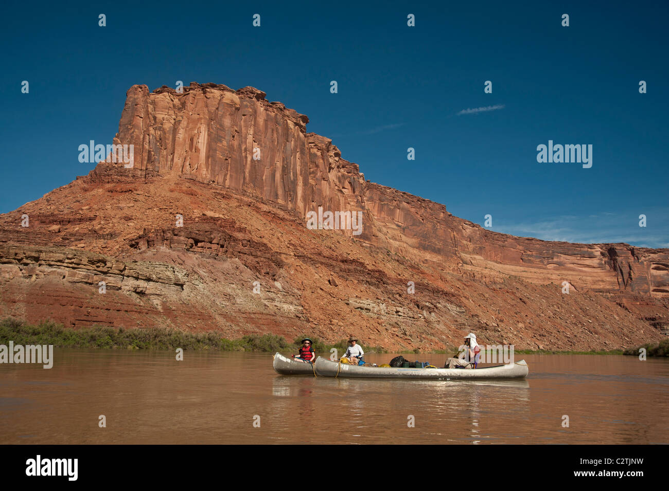 Family canoeing down a desert river in the canyons of Utah Stock Photo