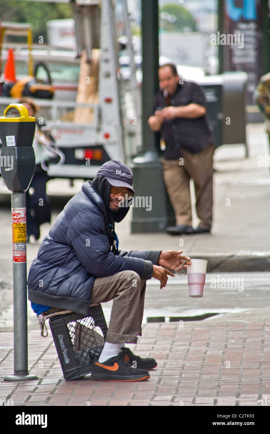 A homeless African American man panhandles for money on the streets of San Francisco. Stock Photo
