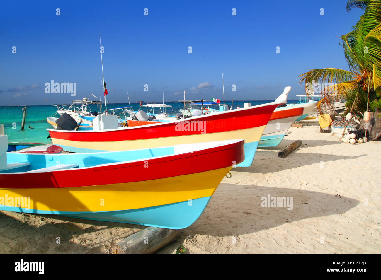 colorful tropical boats beached in the sand Isla Mujeres Mexico Stock Photo