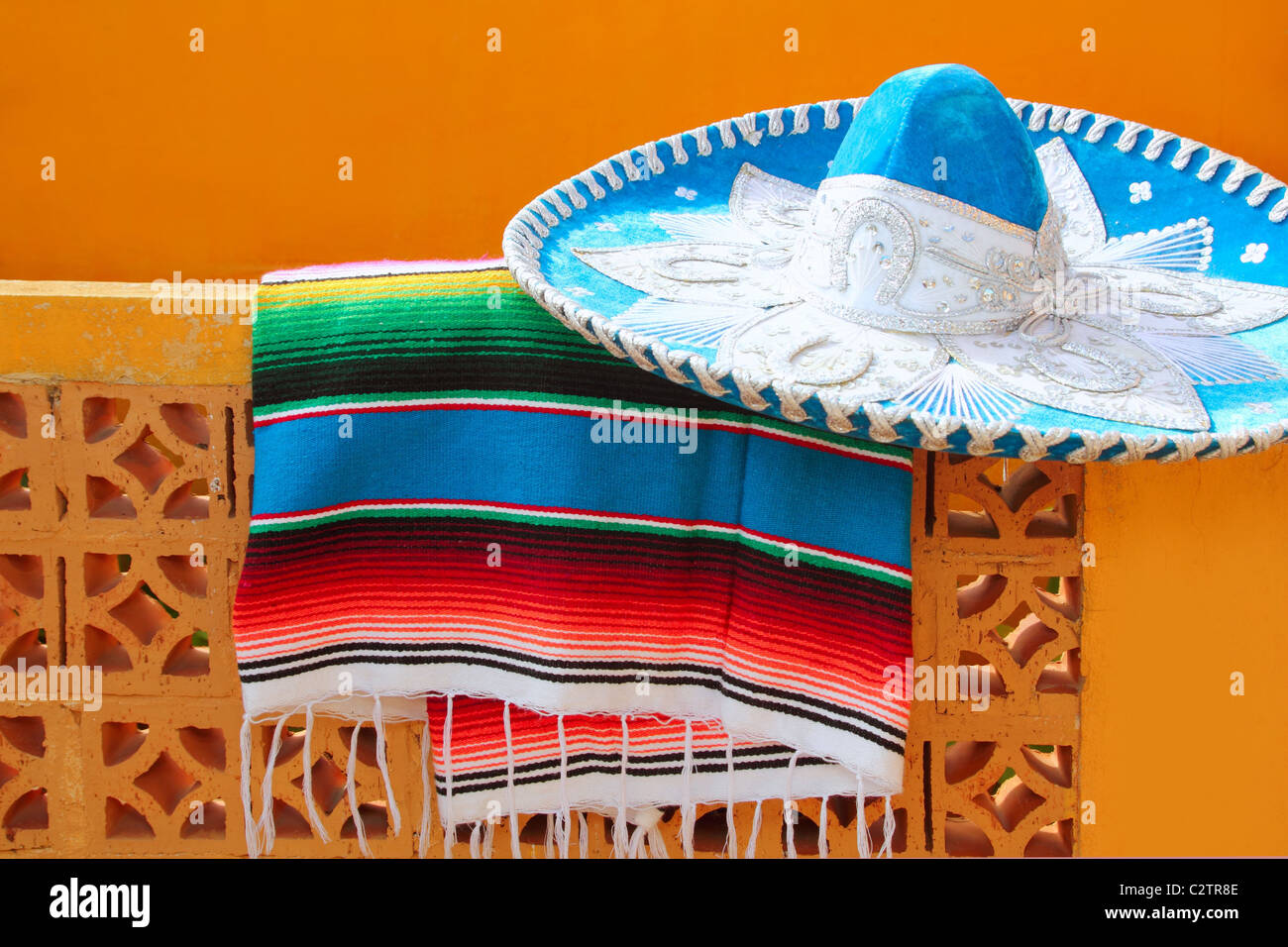 charro mariachi blue mexican hat serape poncho over orange tiles wall Stock Photo