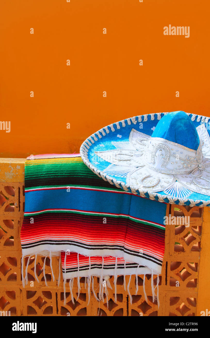 charro mariachi blue mexican hat serape poncho over orange tiles wall Stock Photo