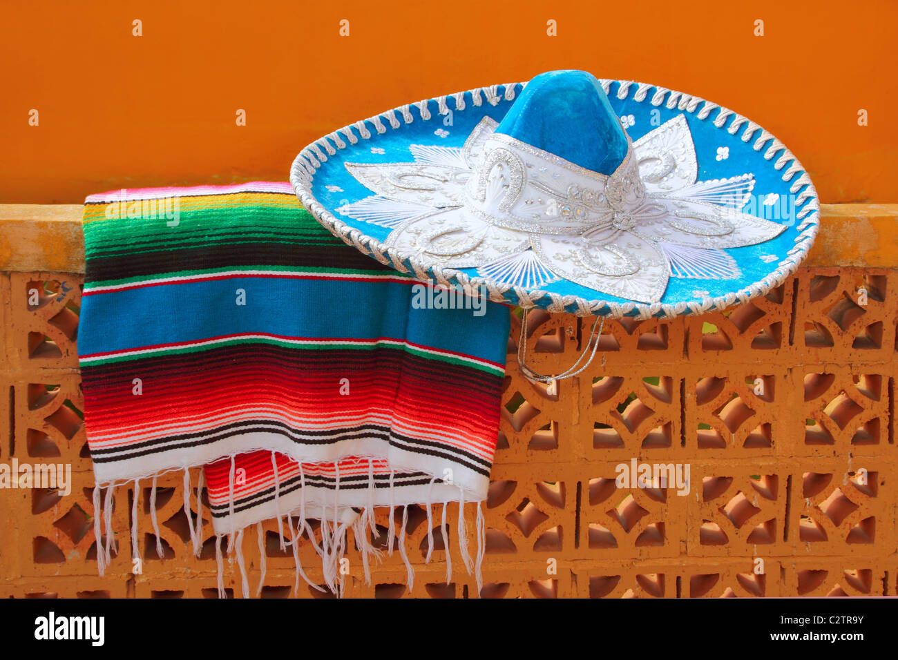 charro mariachi blue mexican hat serape poncho over orange tiles wall Stock Photo