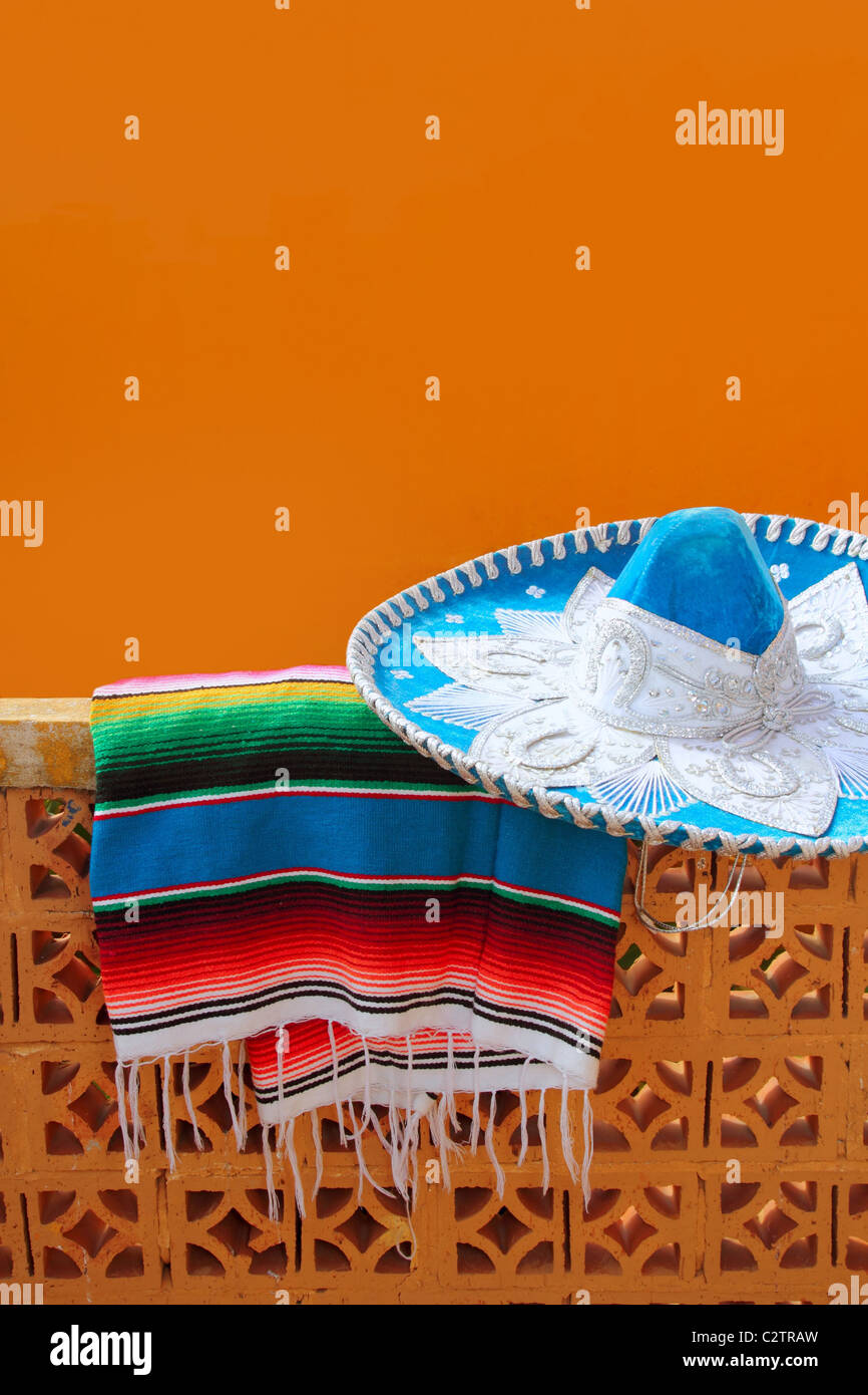 charro mariachi blue mexican hat serape poncho over orange tiles wall Stock Photo