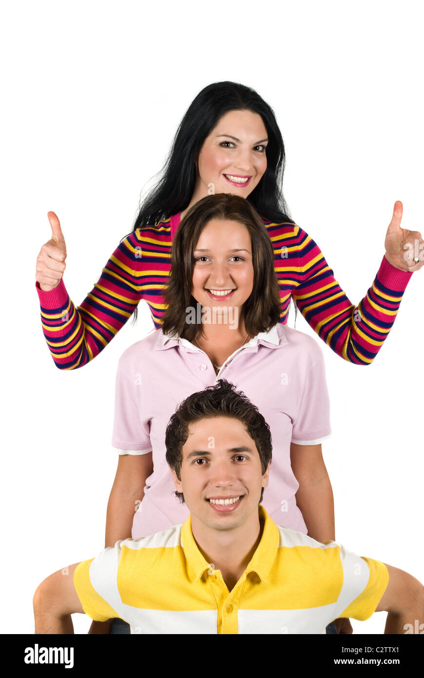 Three happy people friends standing in a line one above the other or overhead each other and brunette girl giving thumbs up Stock Photo