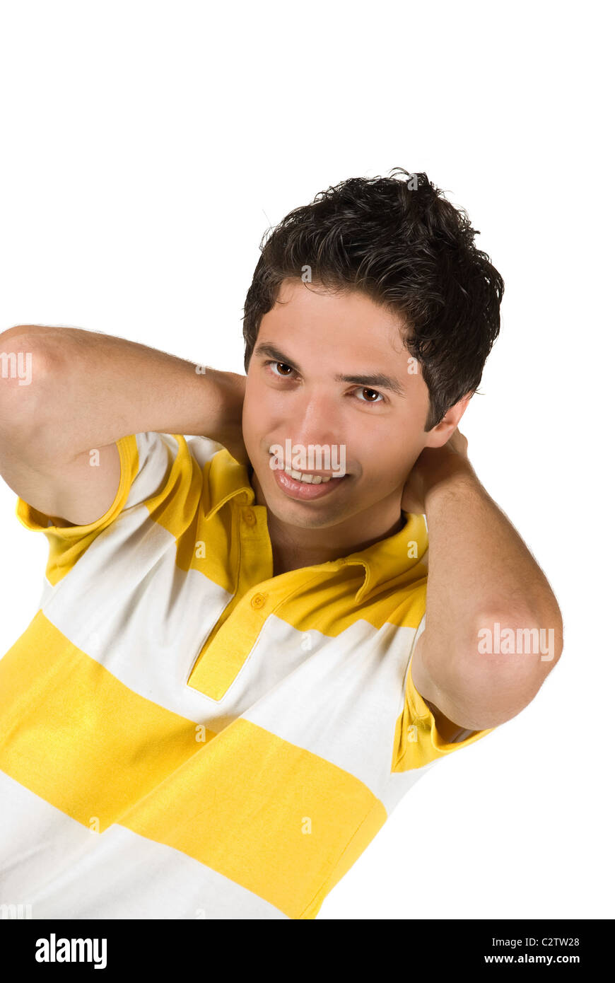 Young fashionable man standing with arms up and hands behind his head ...