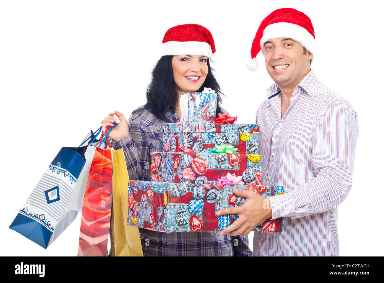 Excited young couple wearing Santa hats and holding several Christmas ...