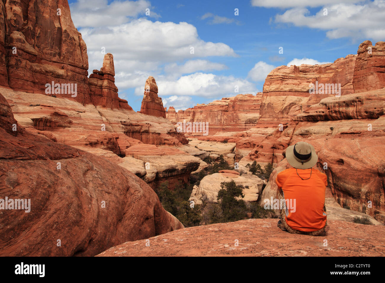 a sitting man admires the view in Canyonlands National Park Stock Photo