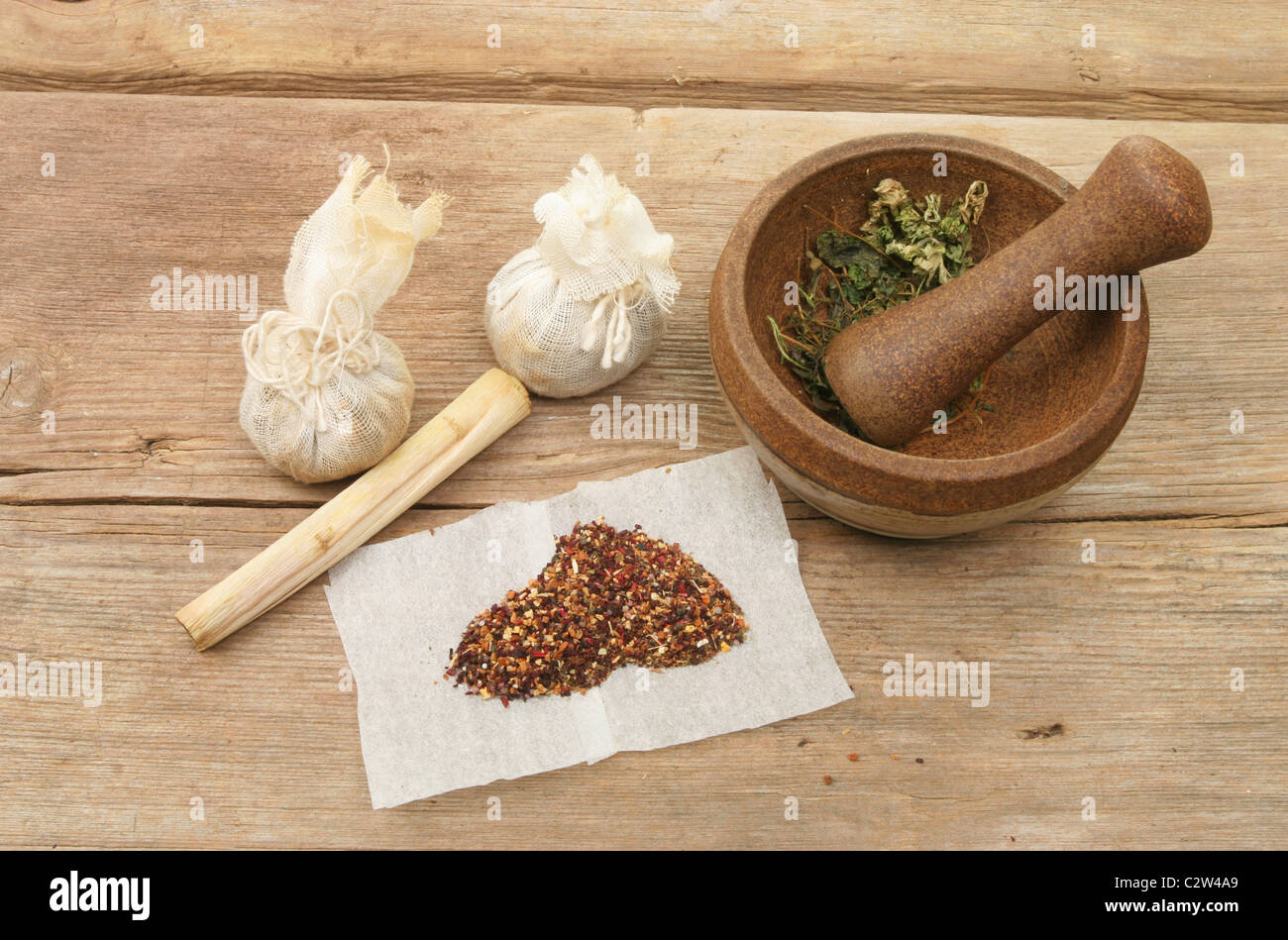 Pestle and mortar and herbal ingredients on weathered wood Stock Photo