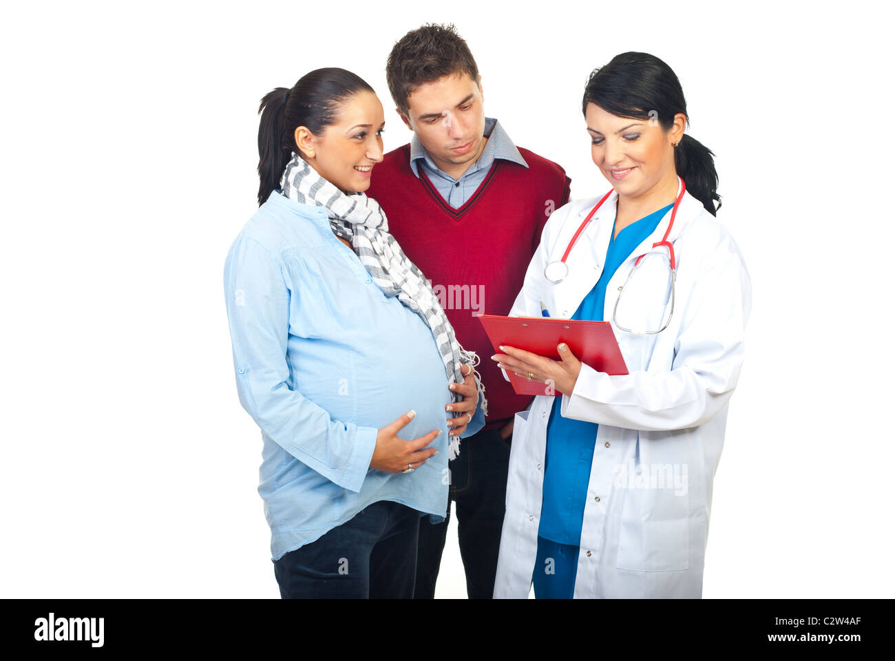 Worried husband with happy pregnant wife having conversation with doctor and giving to pregnant woman prescription Stock Photo