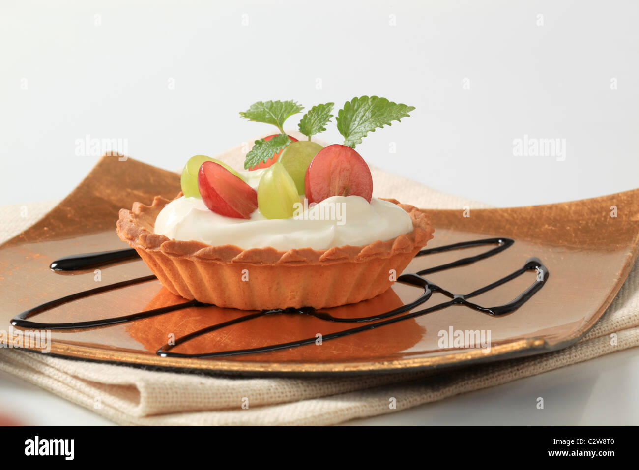 Small cream tart topped with fresh grapes Stock Photo