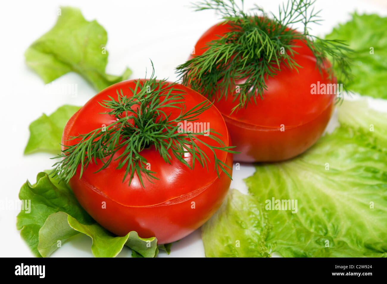 two stuffed tomatoes on lettuce leaf Stock Photo