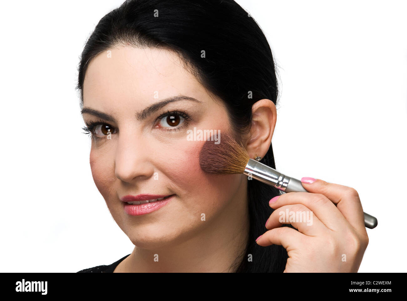 Beautiful woman applying make up blush and looking you