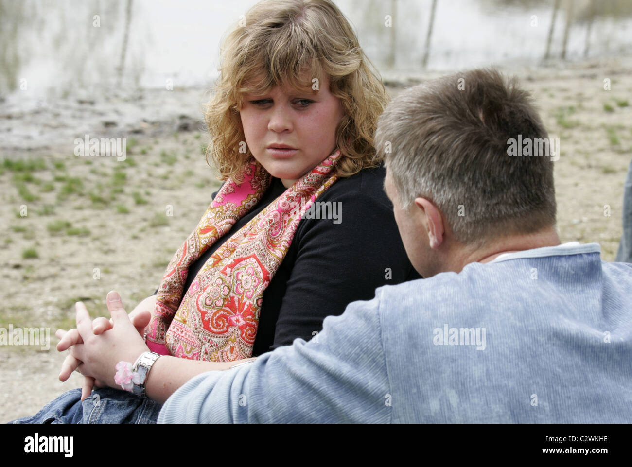 Obese teenage girl having an unpleasant conversation with her dad outside. Stock Photo