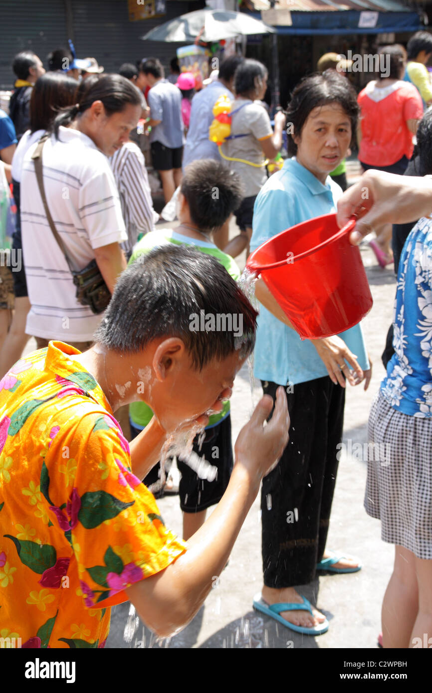 Boy washing his face , Songkran Water Festival at Khao San Road in Bangkok Stock Photo