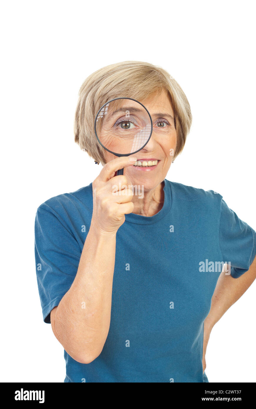 Senior woman looking through magnifying glass and smiling isolated on ...