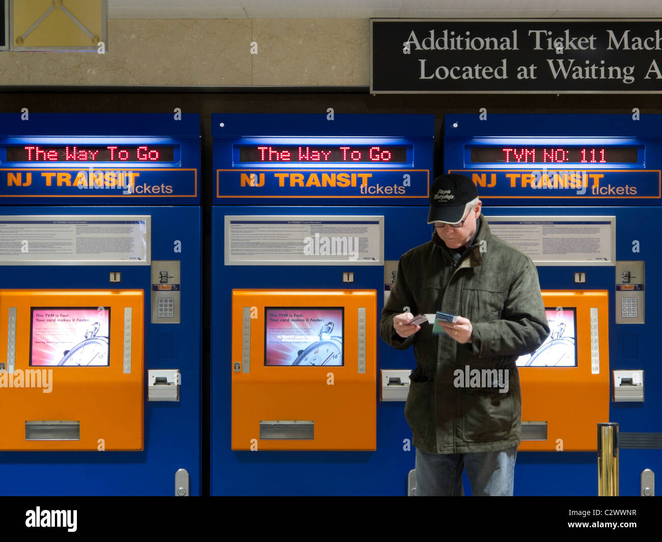 Man Purchasing New Jersey Transit Train Tickets at Self Serve Vending Machine, Penn Station, NYC Stock Photo