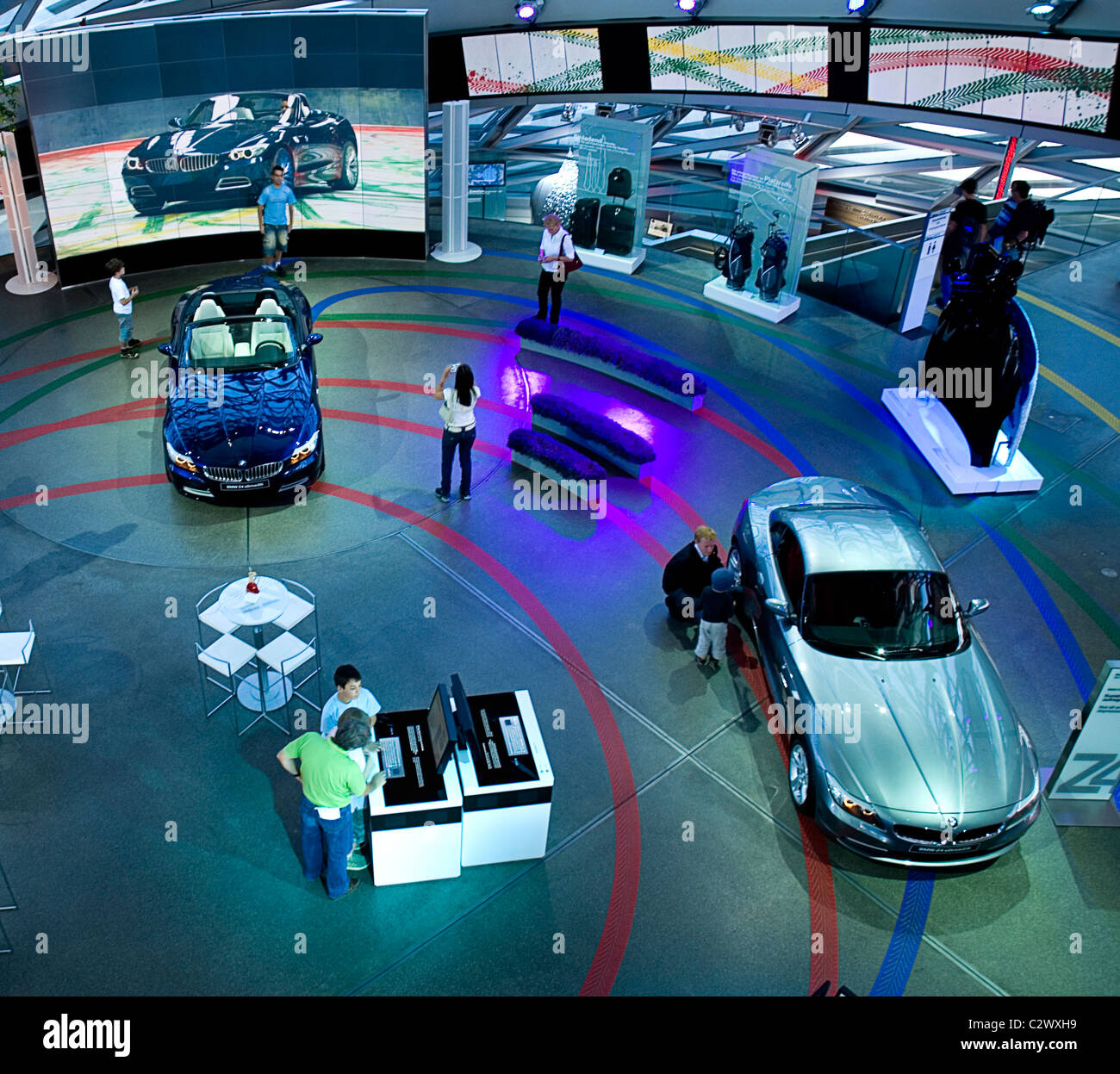 Germany, Bavaria, Munich, BMW World, People in showroom examining new BMW cars. Stock Photo