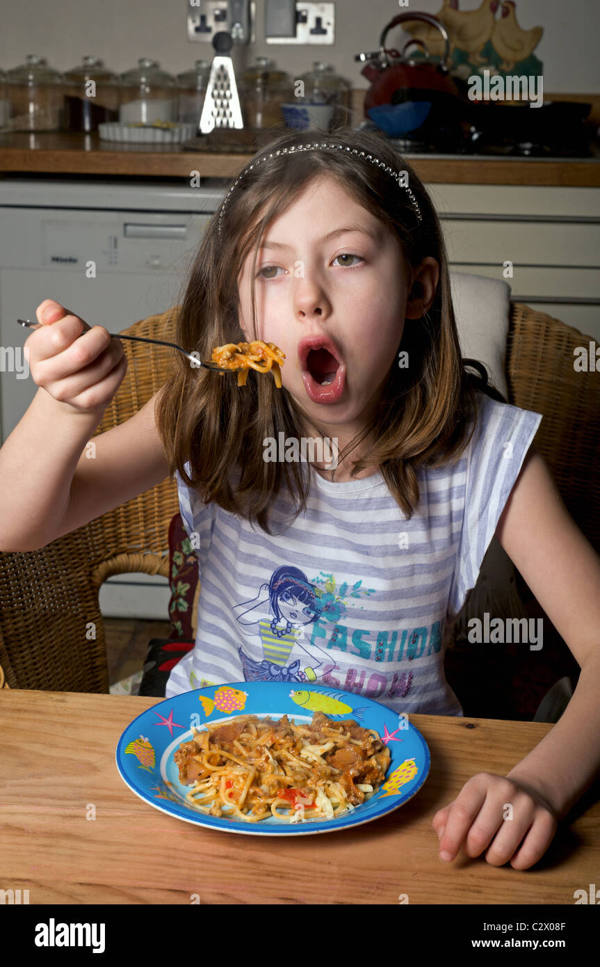 Young British girl eating spaghetti while watching tv Stock Photo Alamy