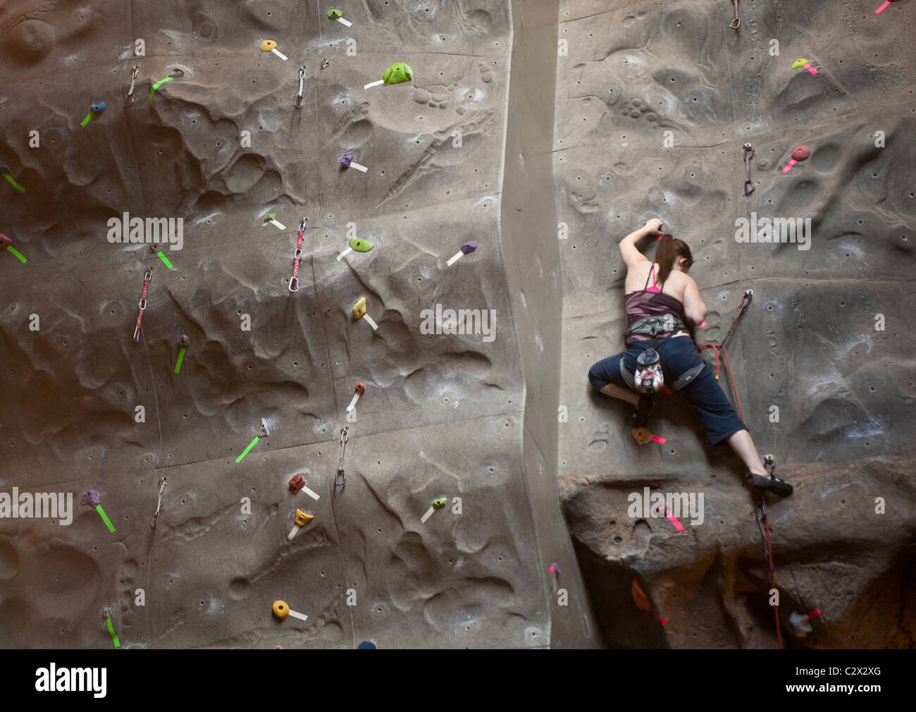 Teen female climbing rock indoors climb rope harnes Stock Photo Alamy