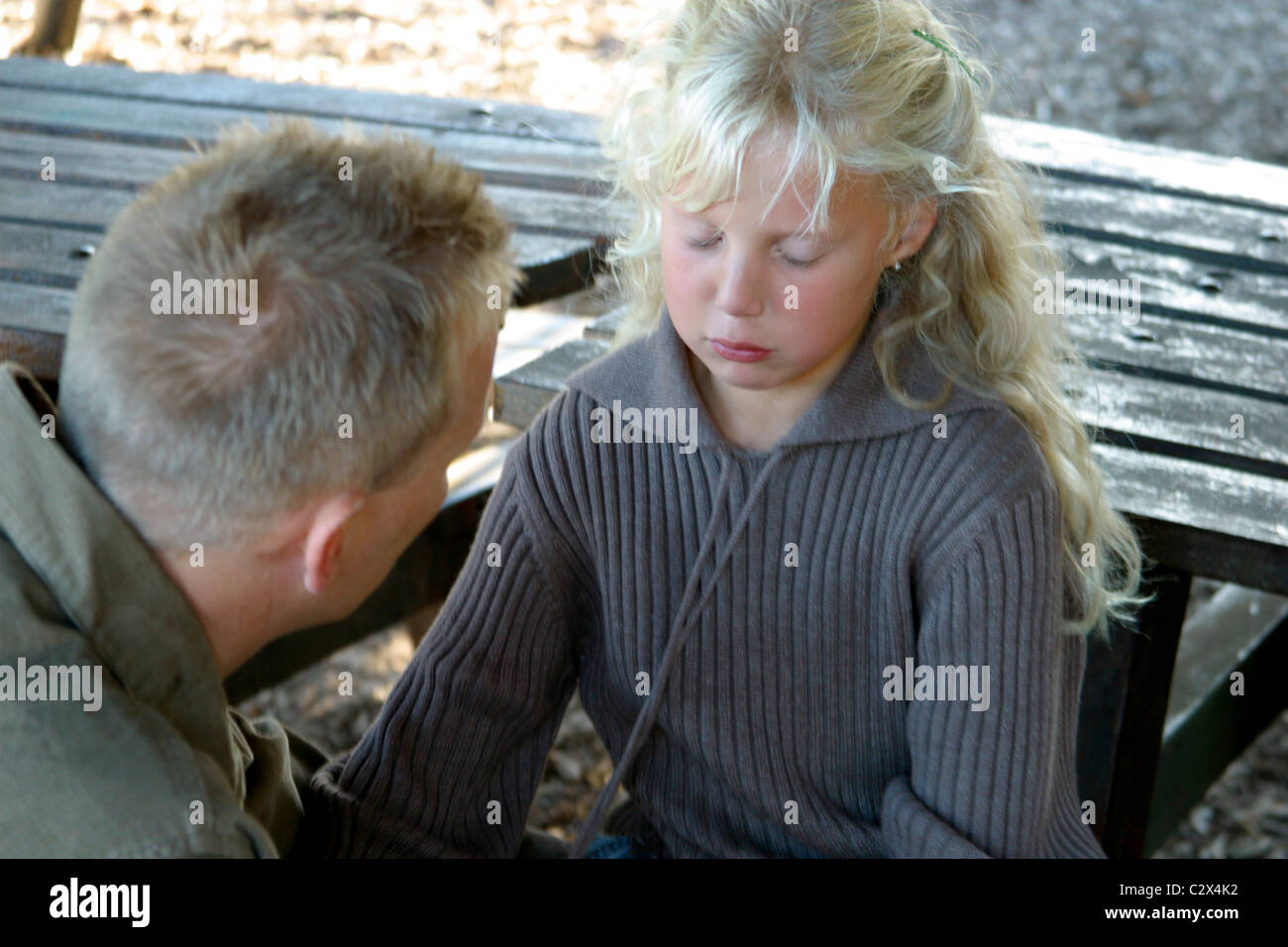 Indulgent father disciplining young girl outside Stock Photo