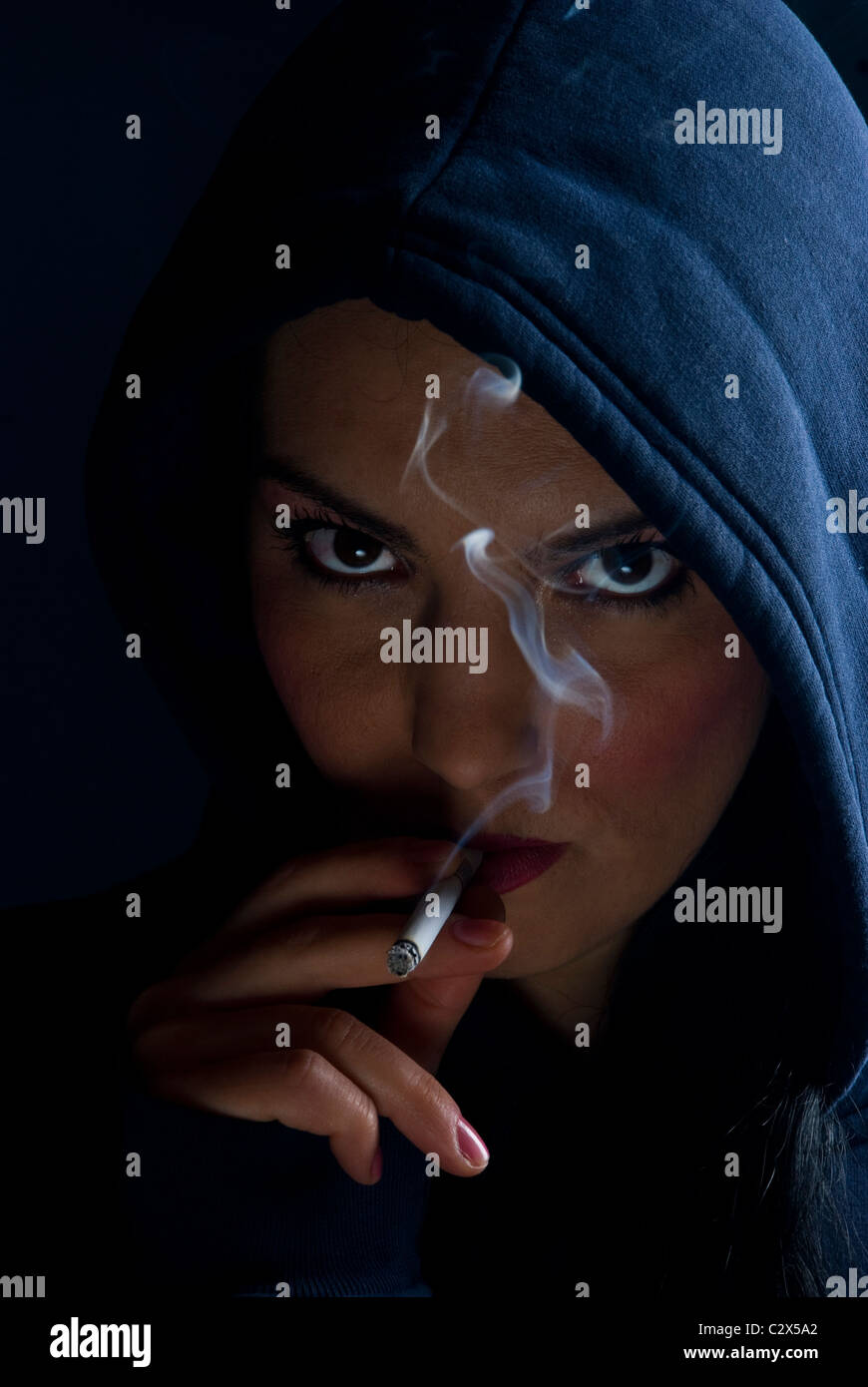 bad girl smoking Bad girl in a hood smoking in darkness and looked provocative Stock Photo -  Alamy
