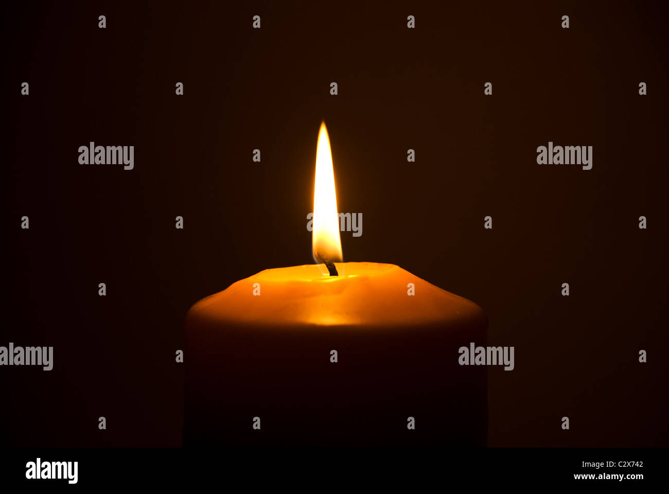Close up of single candle light in darkness Stock Photo - Alamy