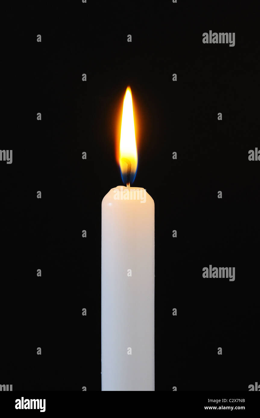 White candle against a black background Stock Photo - Alamy