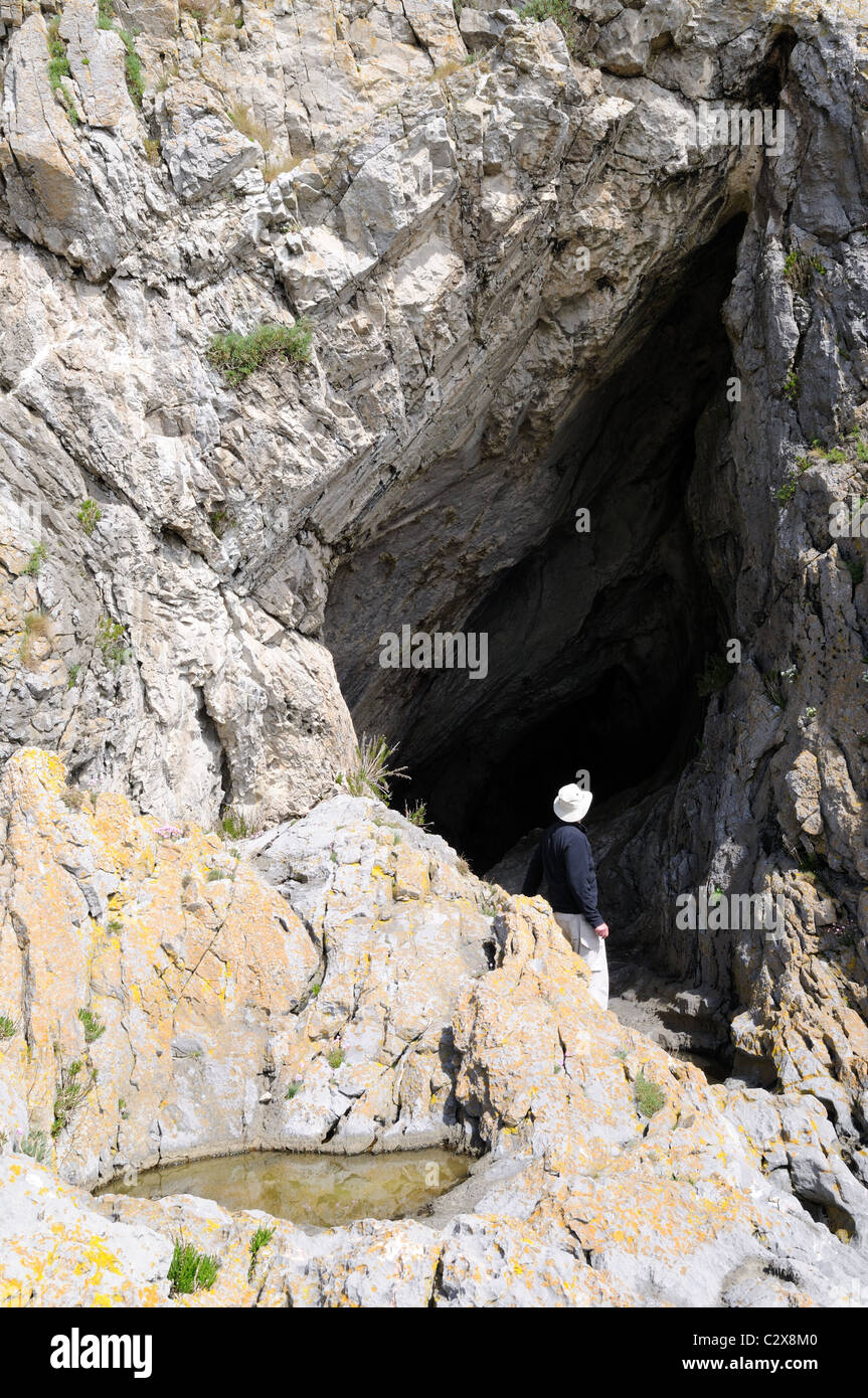 Man standing outside Paviland Cave where the  of The Red Lady of Paviland was discovered Gower Glamorgan Wales Cymru  UK GB Stock Photo