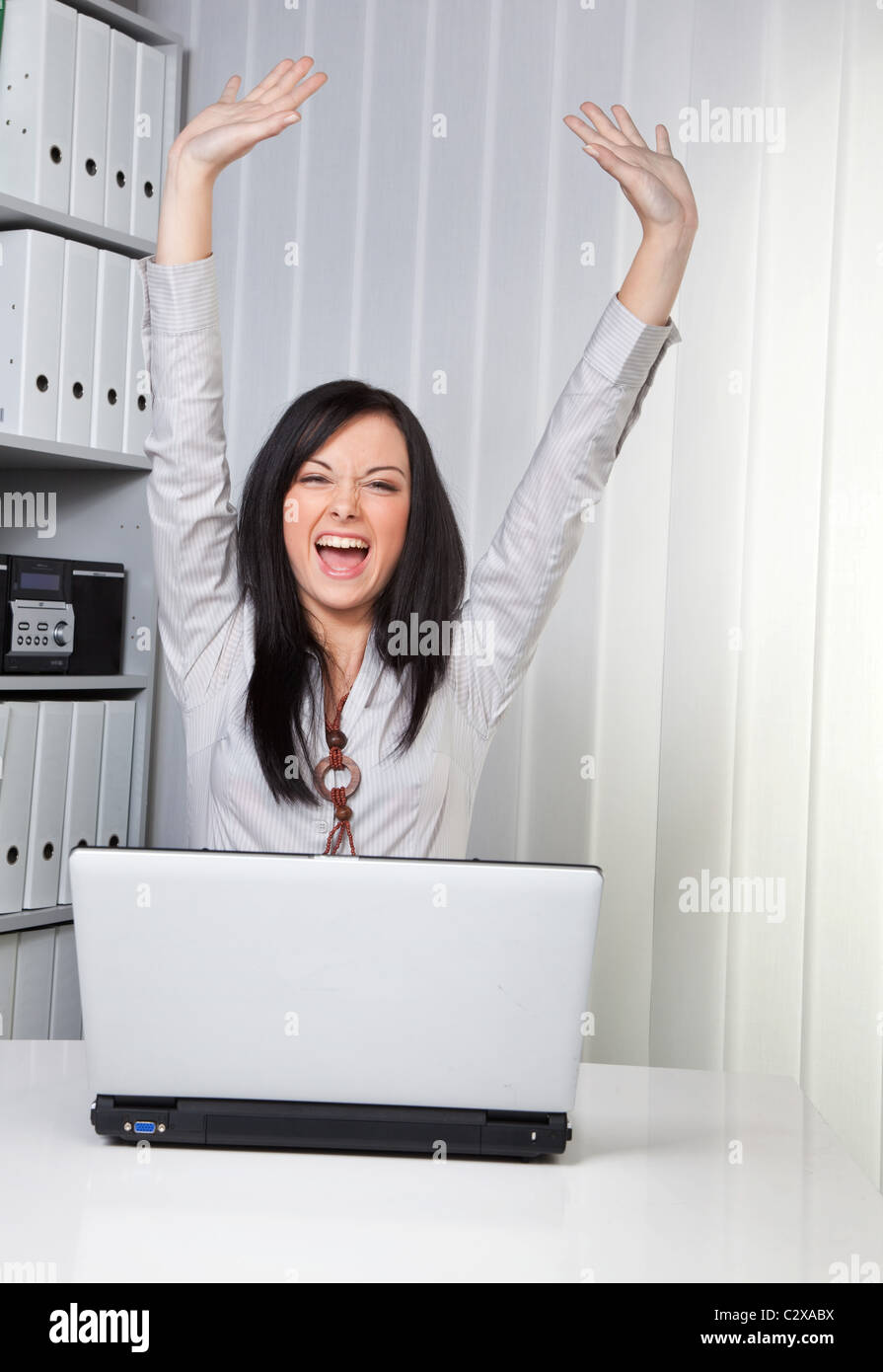 Happy young woman at her laptop Stock Photo