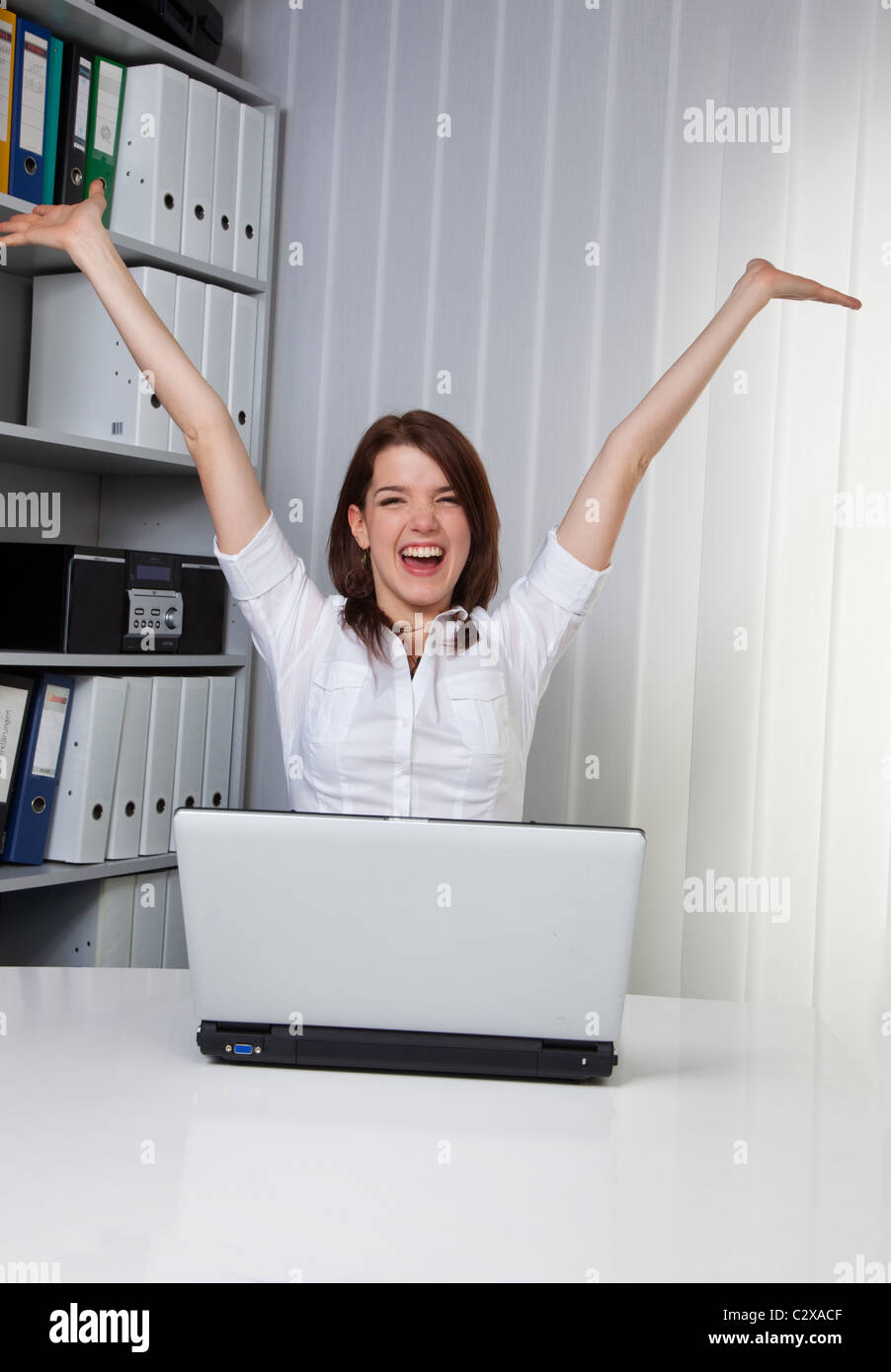 Happy young woman at her laptop Stock Photo