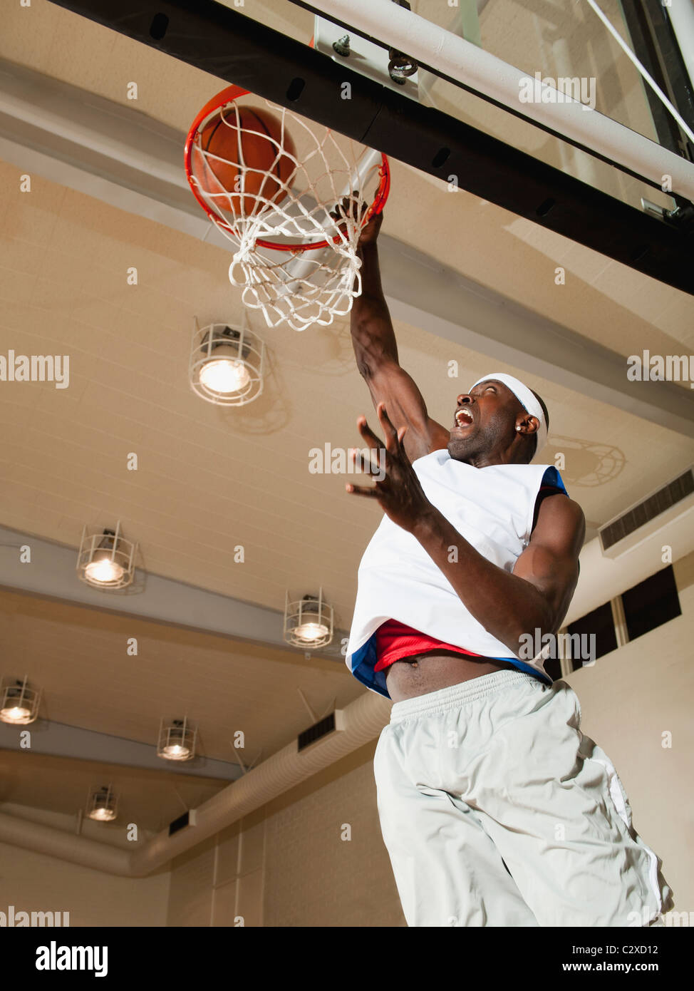 Black man shooting baskets on basketball court Stock Photo