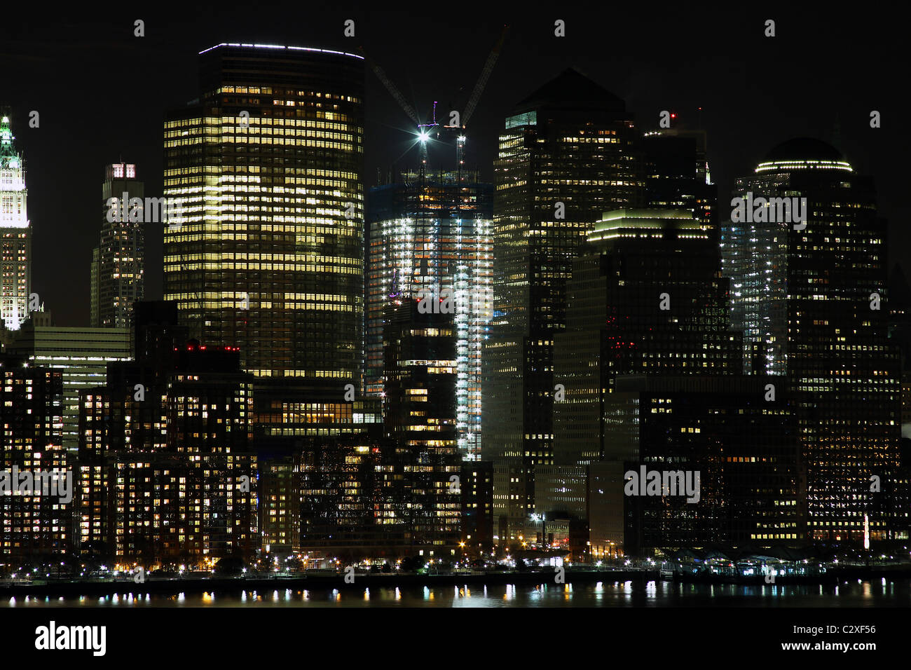 Manhattan financial district at night, showing the new World Trade Center under construction. Note the two giant cranes on top. Stock Photo