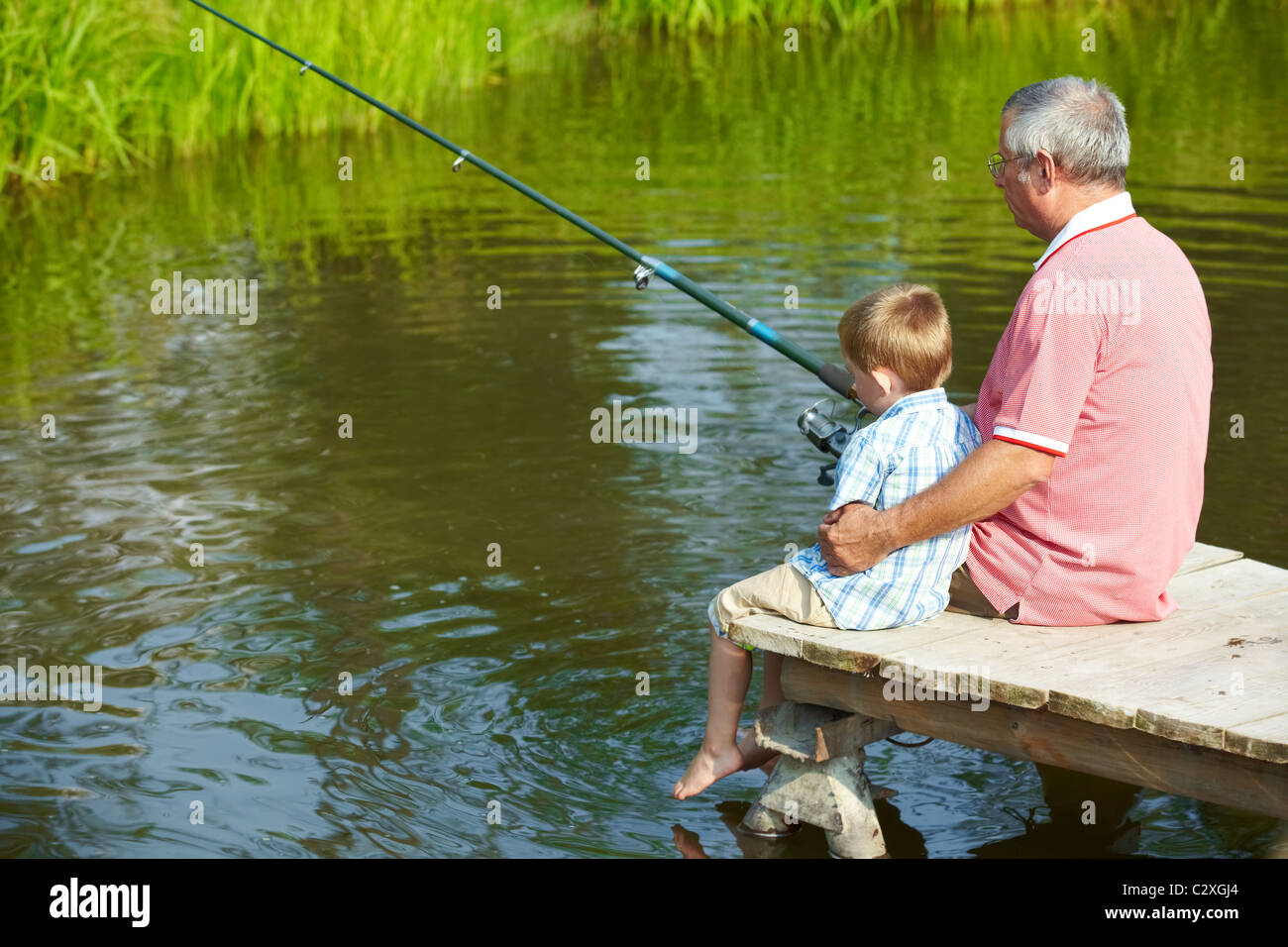 Дедушка ловит рыбу. Дедушка рыбачит с внуком. Дед с внуком на рыбалке. Дед и внук рыбачат. Дедушка с внуками на рыбалке.