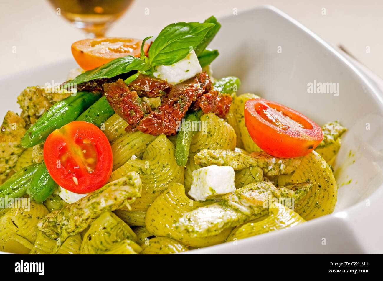 fresh lumaconi pasta and pesto sauce with vegetables and sundried tomatoes,tipycal italian food Stock Photo