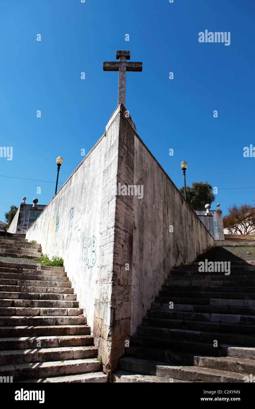 A crucifix stands between stairs running to the Capela de Santo Amaro (Chapel of St Amaro) in Lisbon, Portugal. Stock Photo