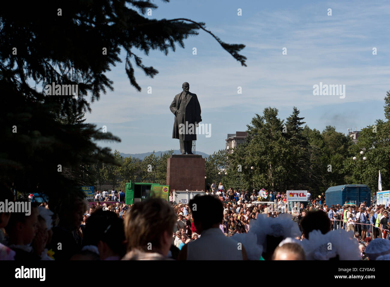A statue of Lenin looks down on on people celebrating the holiday marking the anniversary of the founding of the city, in Yuzhno Stock Photo