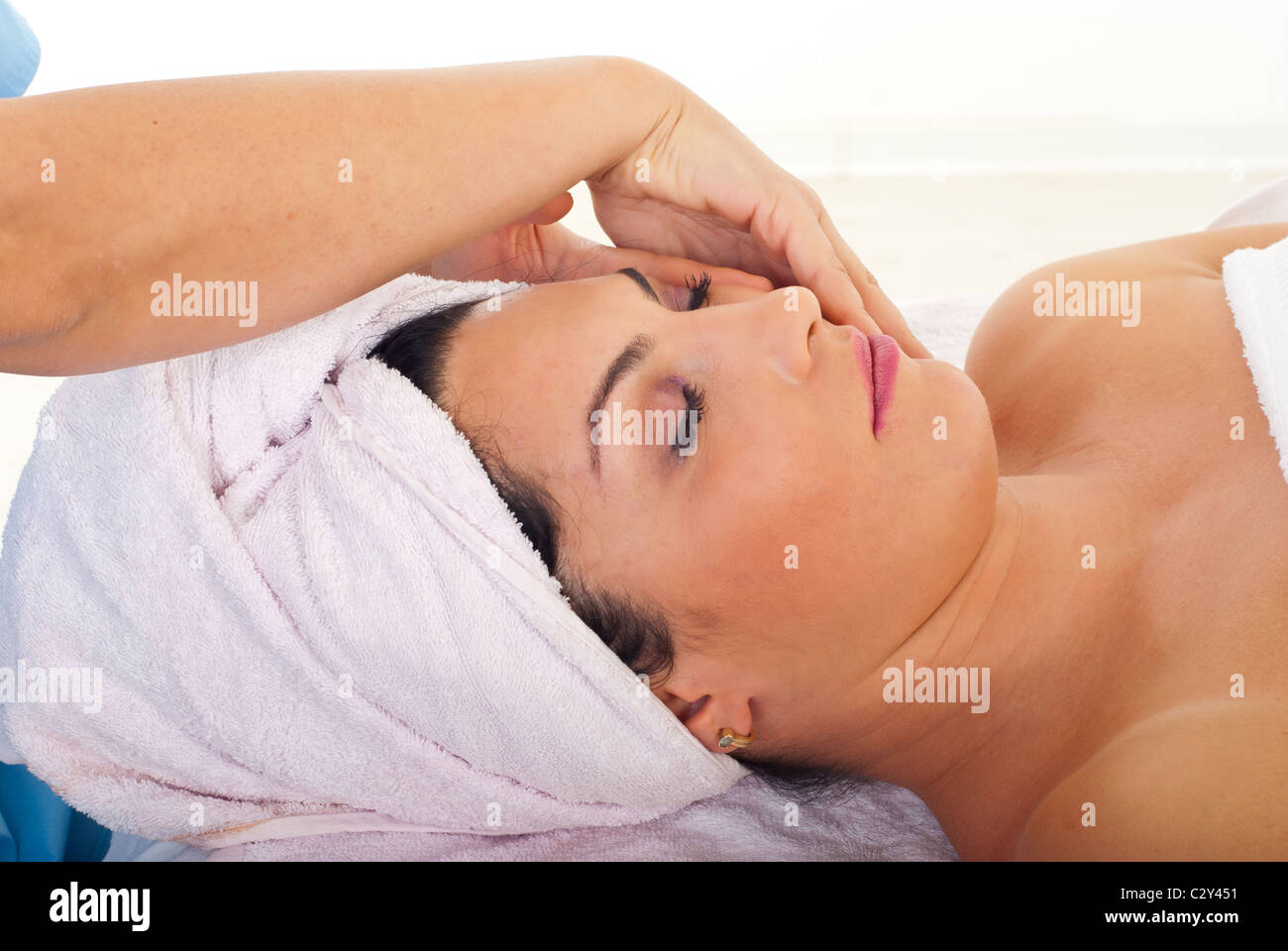 Cute woman receiving facial massage at spa salon Stock Photo