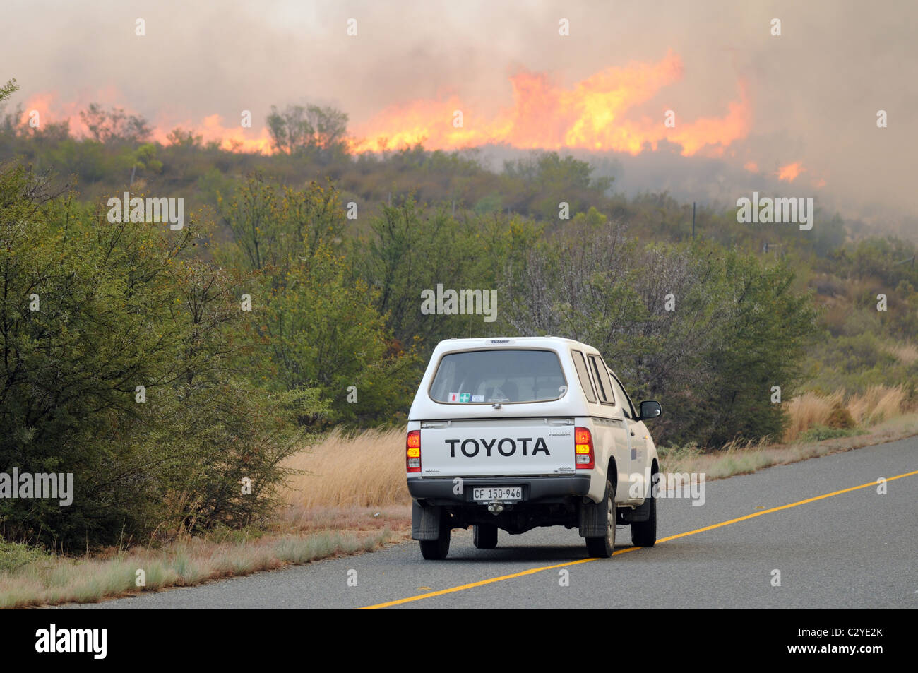 Bush fire, road, cars, smoke, flames, dark skies Stock Photo
