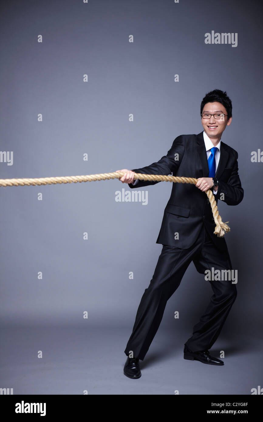 businessman posing pull the rope Stock Photo - Alamy