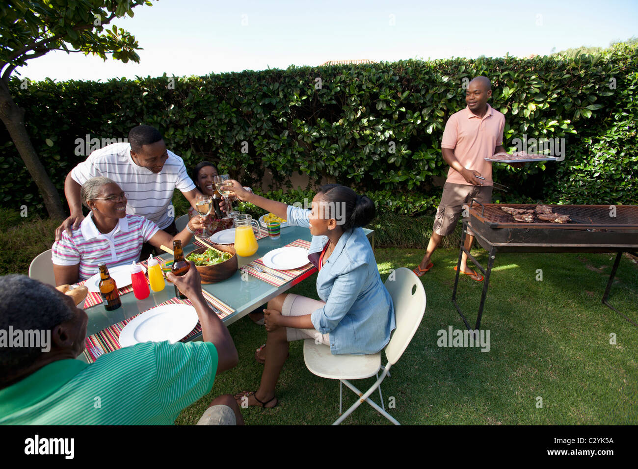https://c8.alamy.com/comp/C2YK5A/people-sitting-outside-with-braai-in-background-johannesburg-south-C2YK5A.jpg