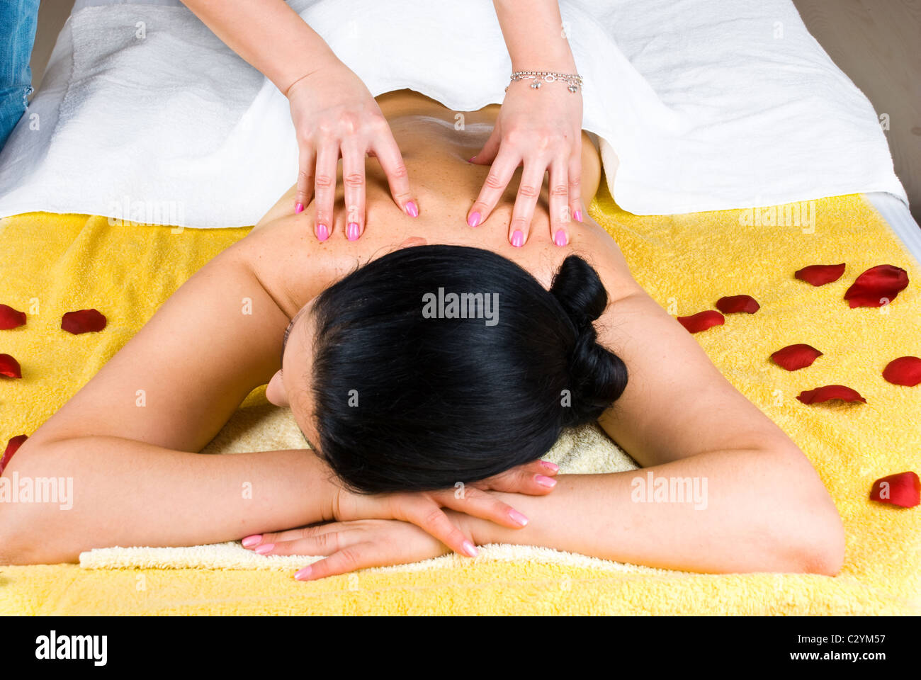 Beautician giving a back massage to a young woman at spa salon Stock Photo