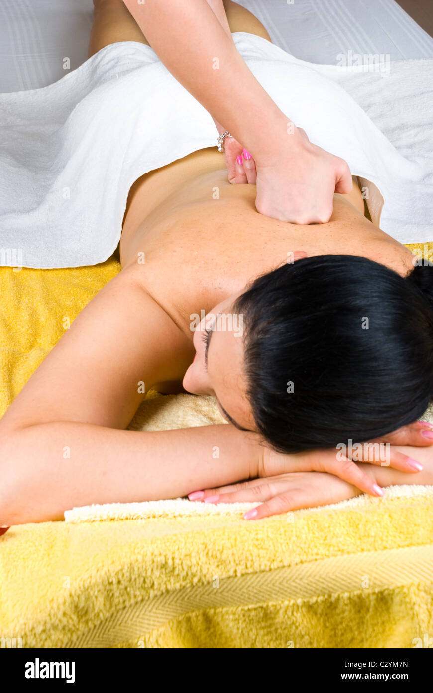 Young female receiving a deep massage on back at spa salon Stock Photo