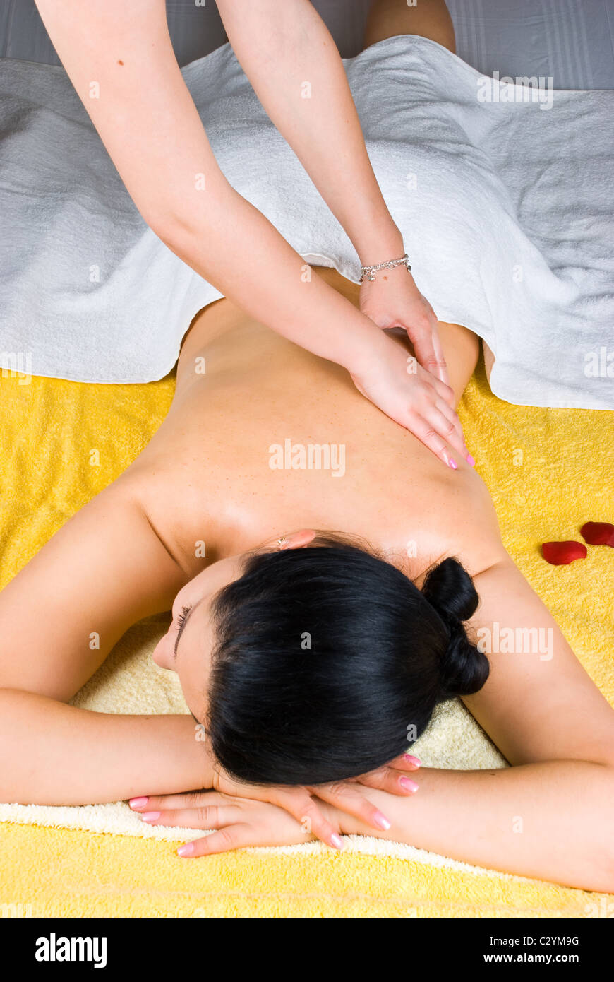 Person massaging woman back at spa resort Stock Photo