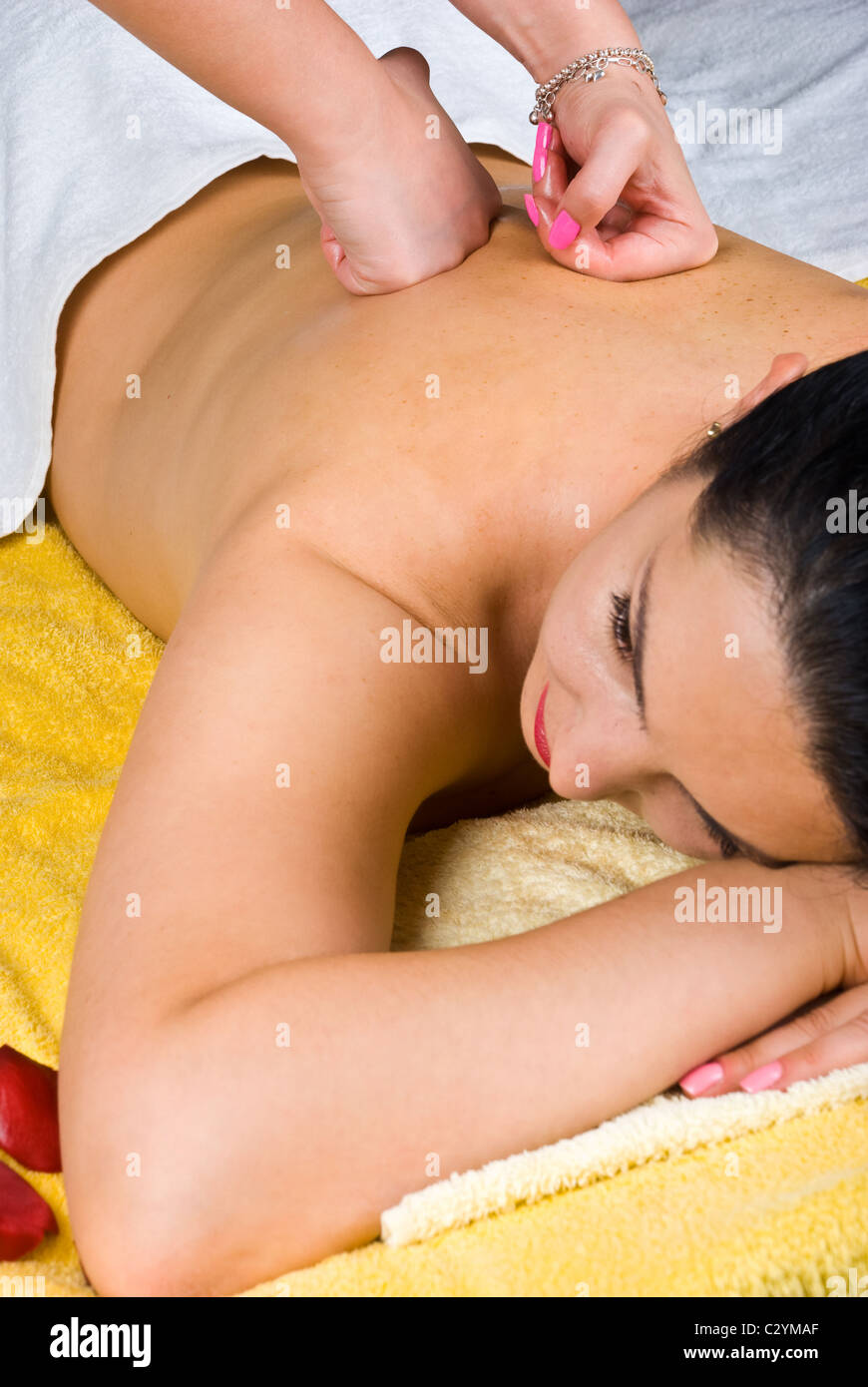 Young woman lying and receiving a back massage at spa salon Stock Photo