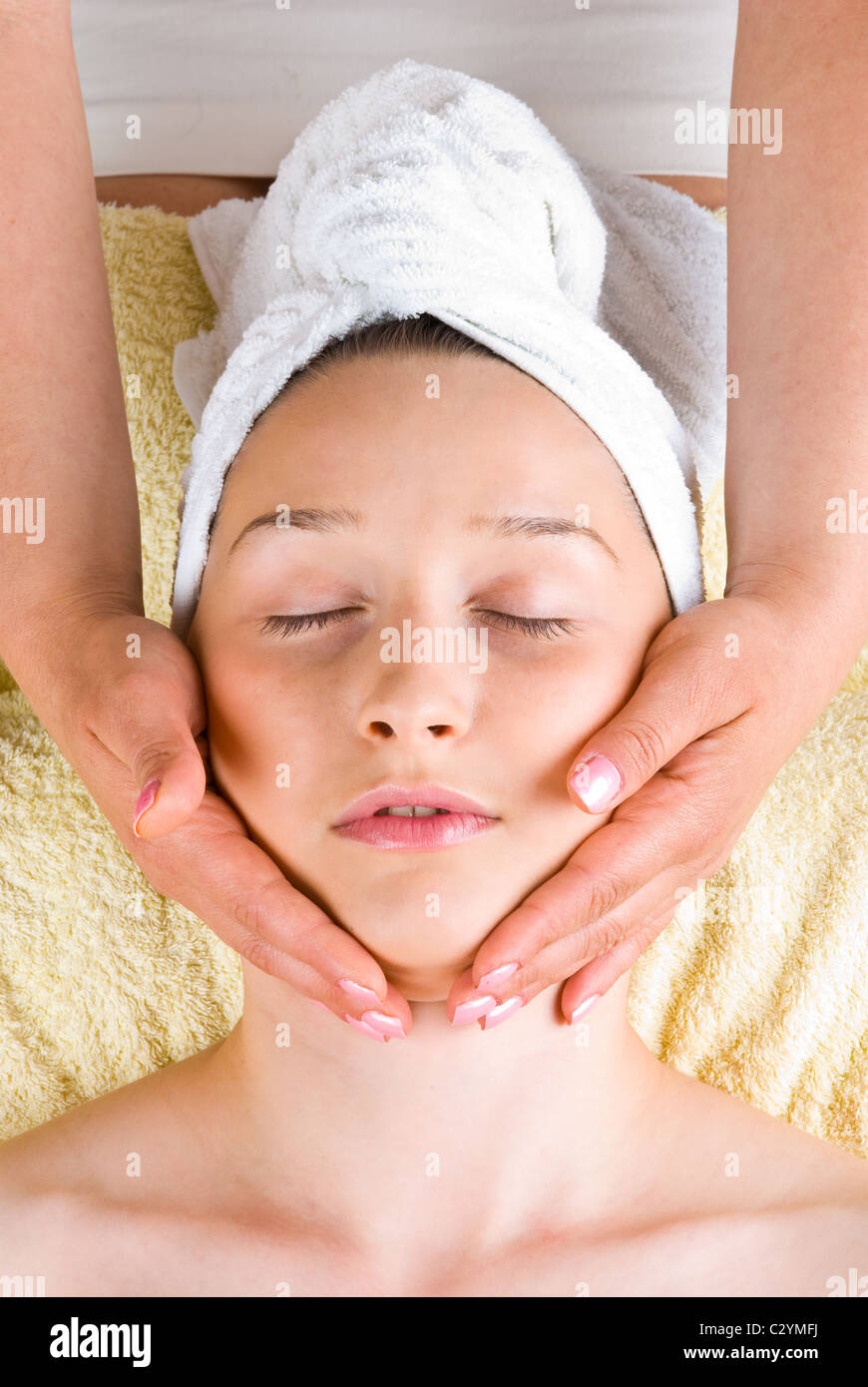 Young woman receiving a facial massage at spa retreat Stock Photo