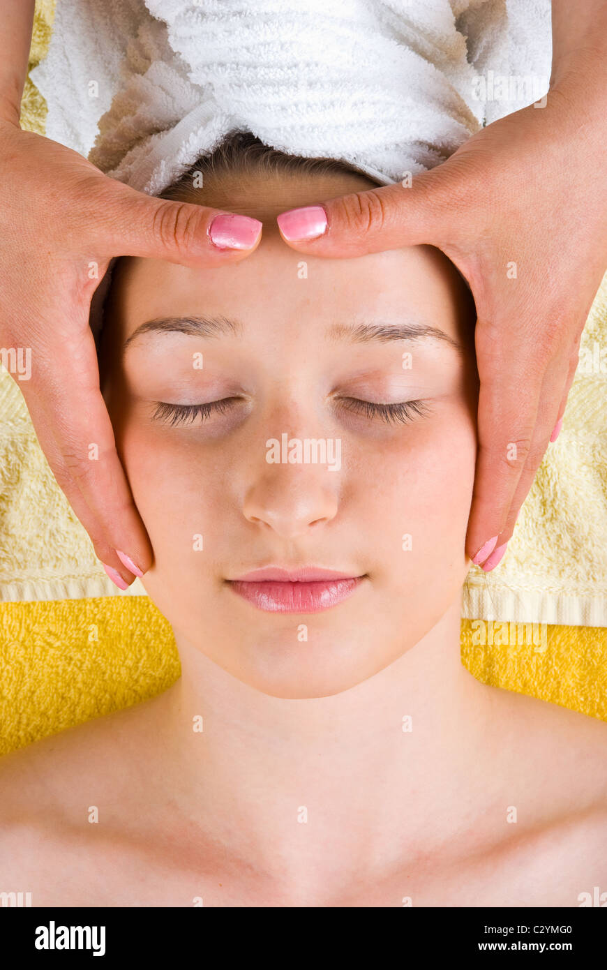 Beautiful young woman getting head massage at spa salon Stock Photo