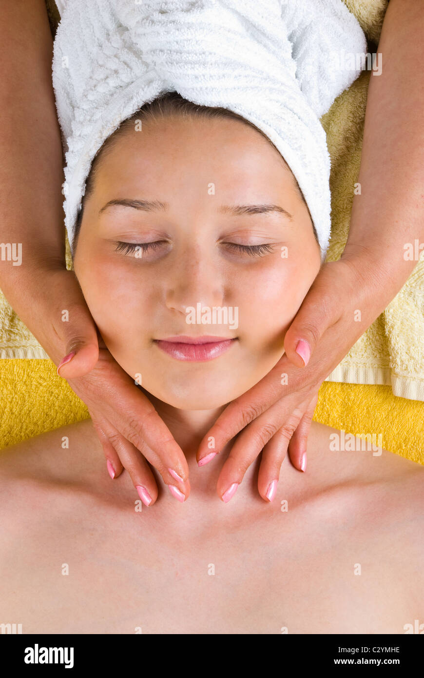 Beautiful female receiving a soft neck massage from a beautician at spa salon Stock Photo